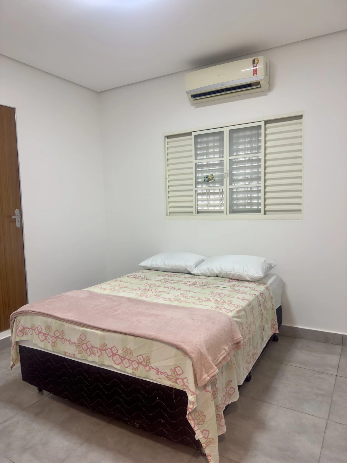 Quarto casal com cama de casal e janela