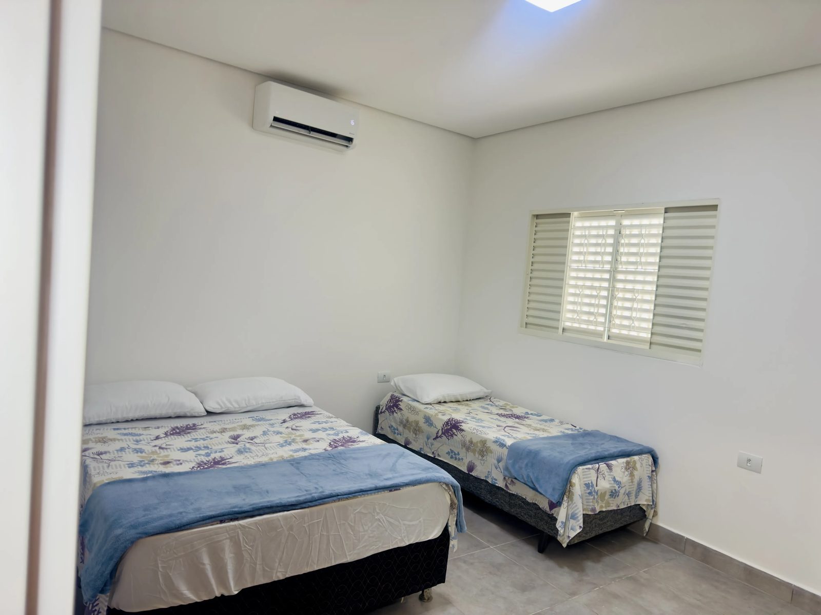 Quarto com cama de casal e solteiro